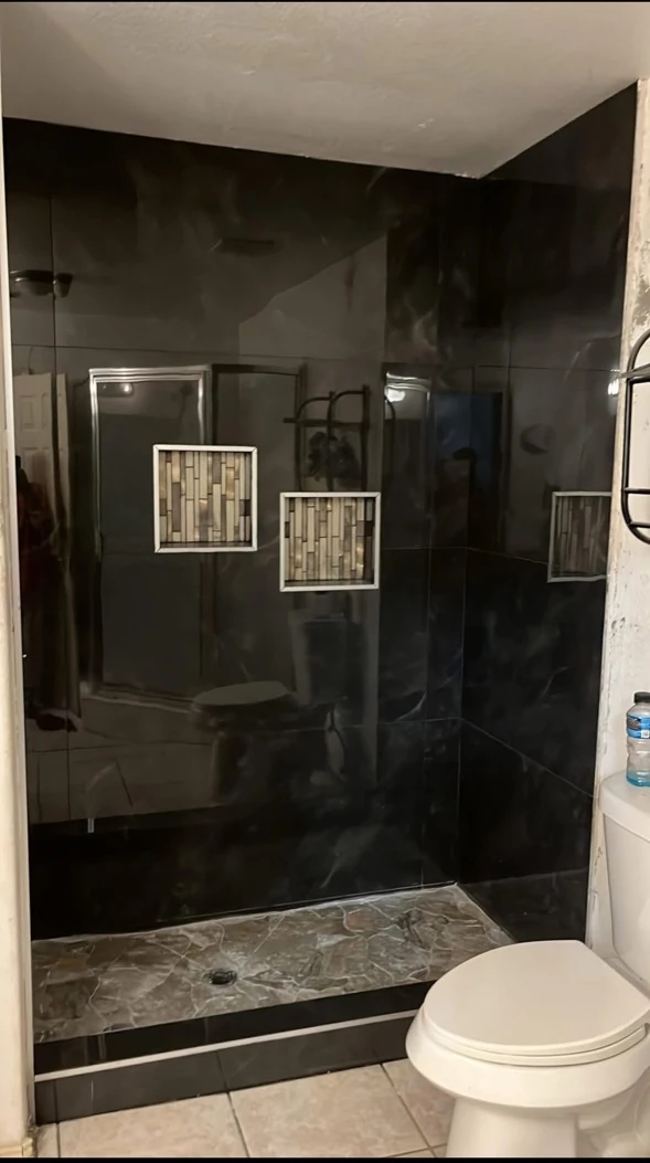 Bathroom with dark shower surround.