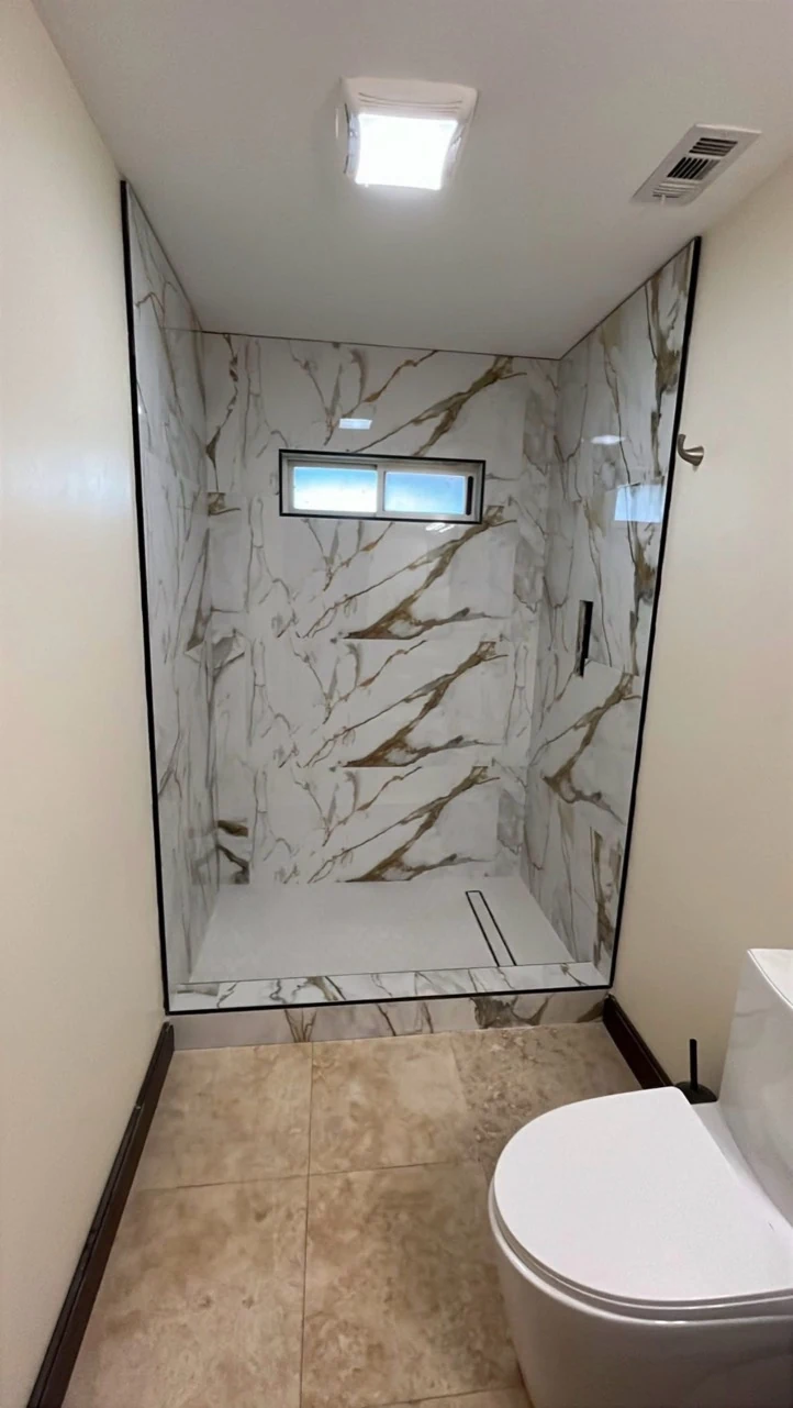 Marble-clad shower with a high window.