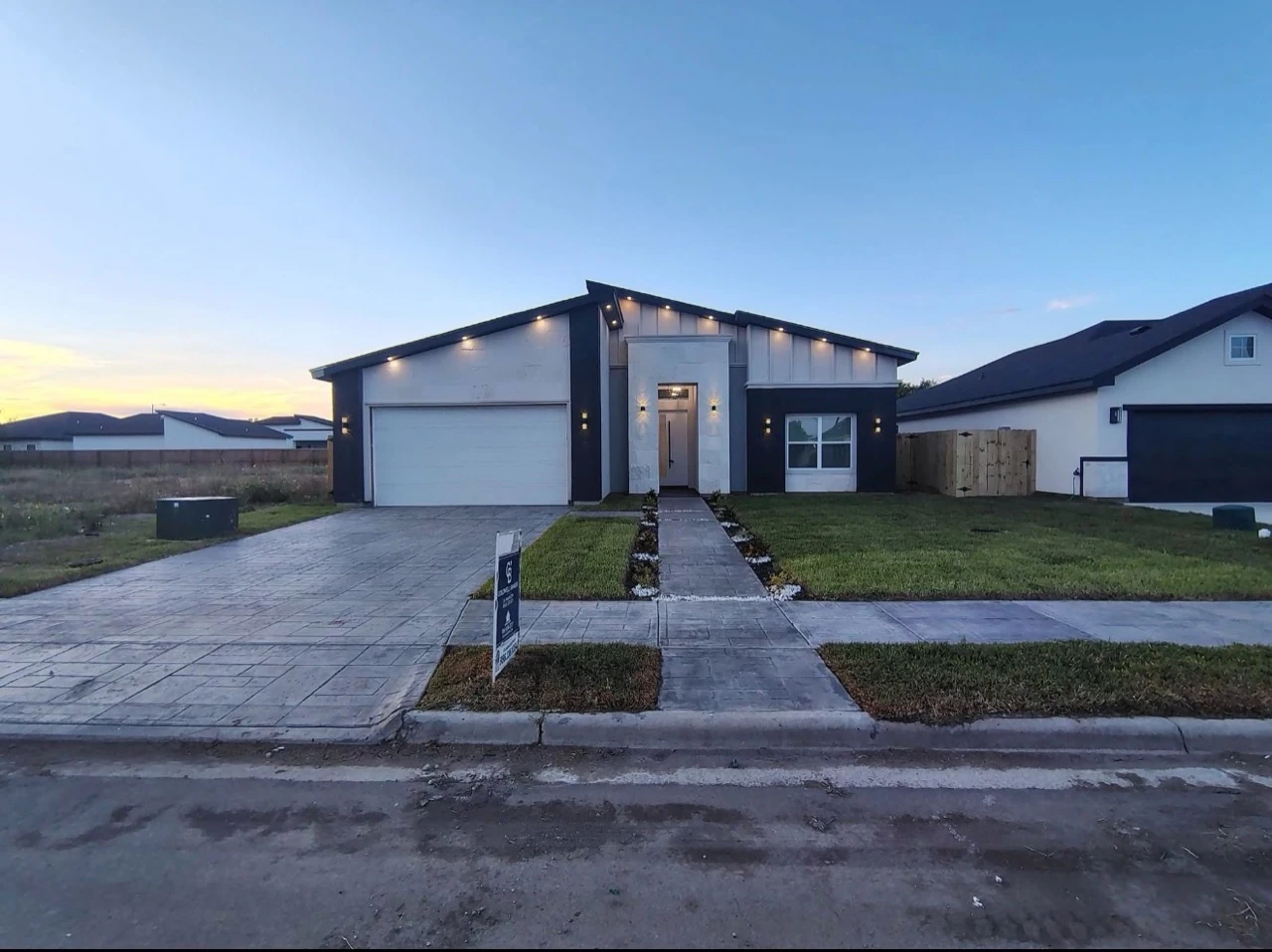 Residential home with a driveway and concrete walkway.